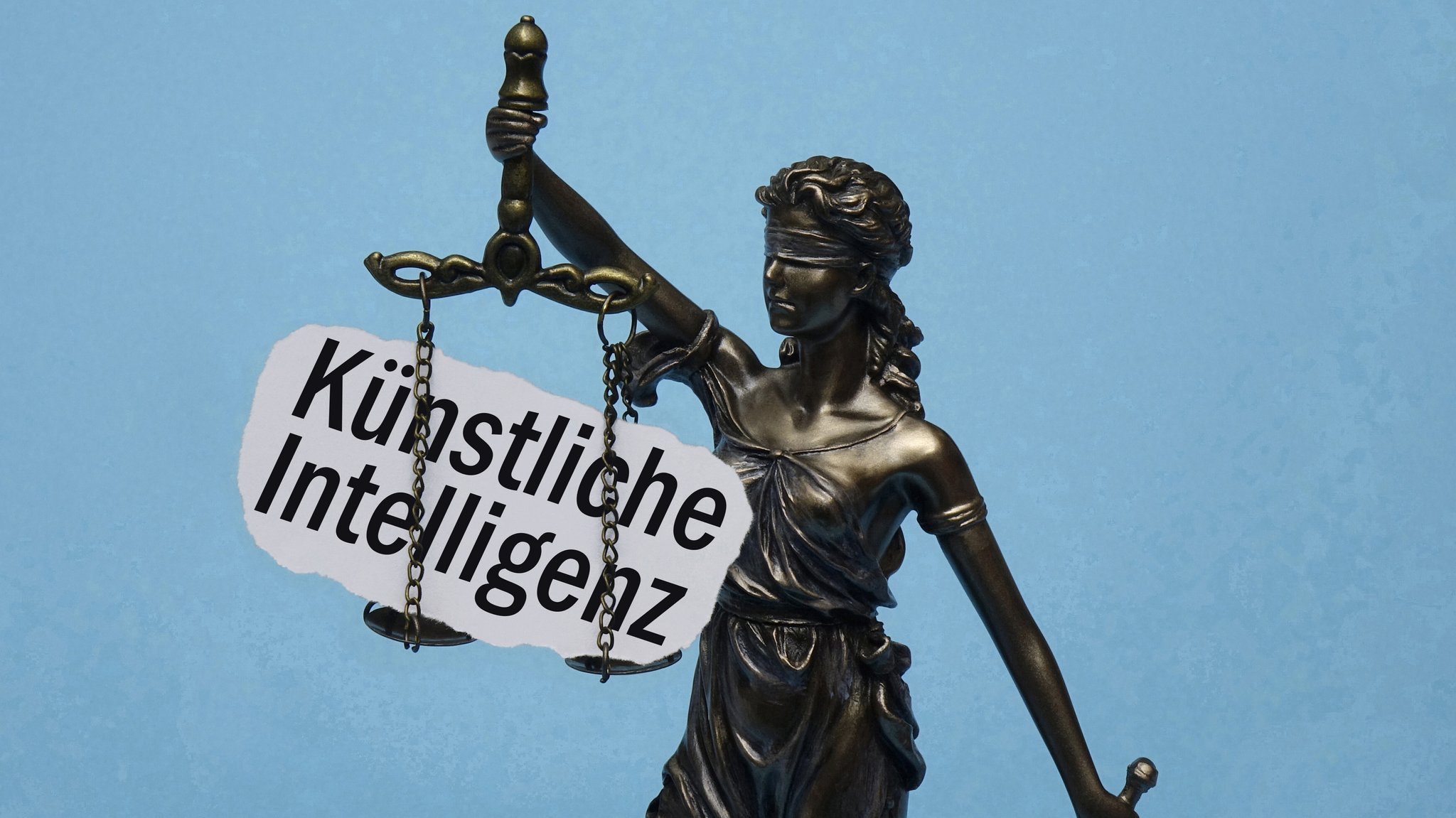 Das Modell der Justitia traegt den Schriftzug Kuenstliche Intelligenz. | Bild: picture alliance / ZB | Sascha Steinach Das Modell der Justitia traegt den Schriftzug Kuenstliche Intelligenz.