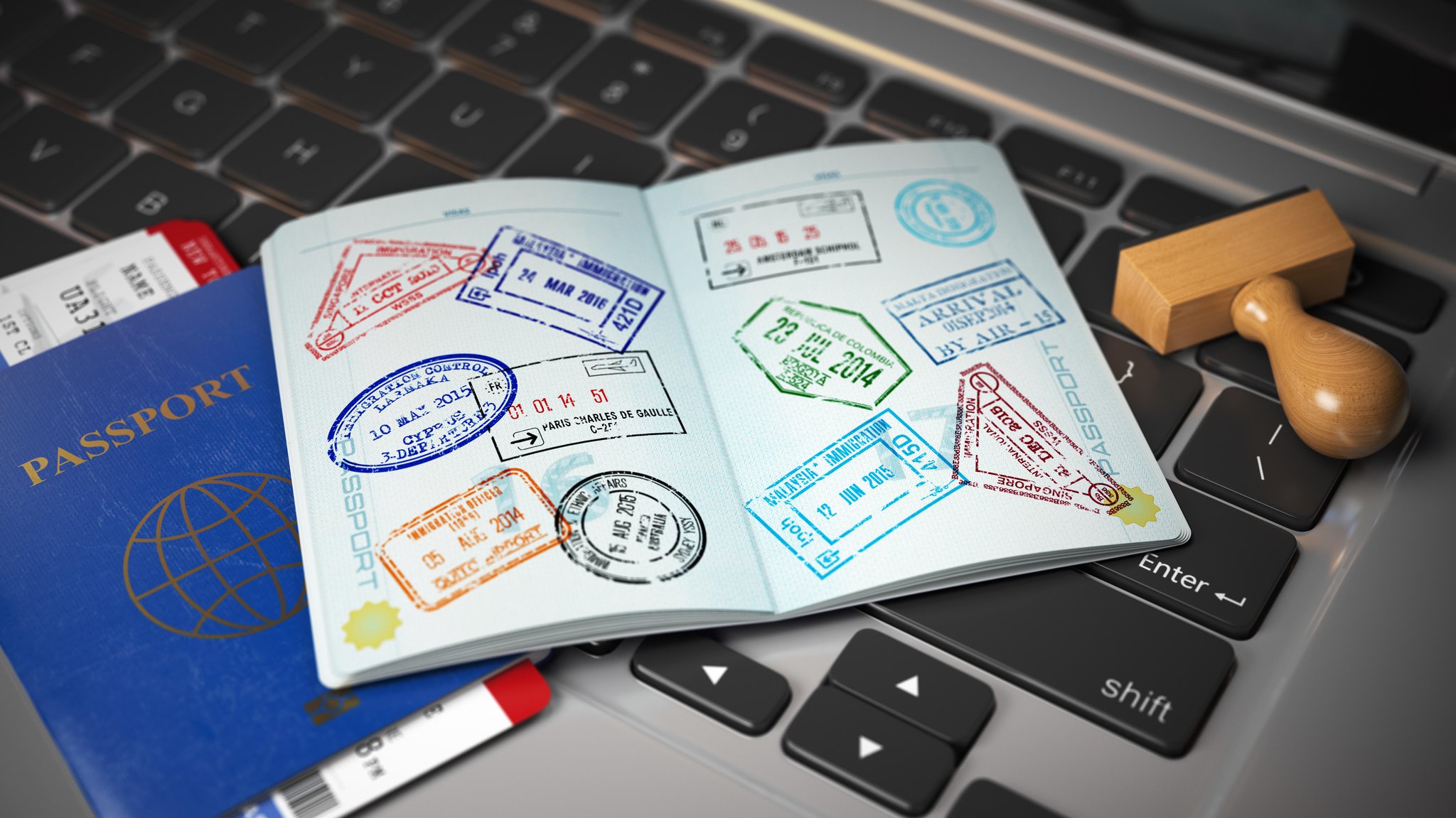 (Symbolbild) Ein offener Reisepass mit vielen Passstempeln liegt auf einem Laptop | Bild: picture alliance / Zoonar | Maksym Yemelyanov (Symbolbild) Ein offener Reisepass mit vielen Passstempeln liegt auf einem Laptop