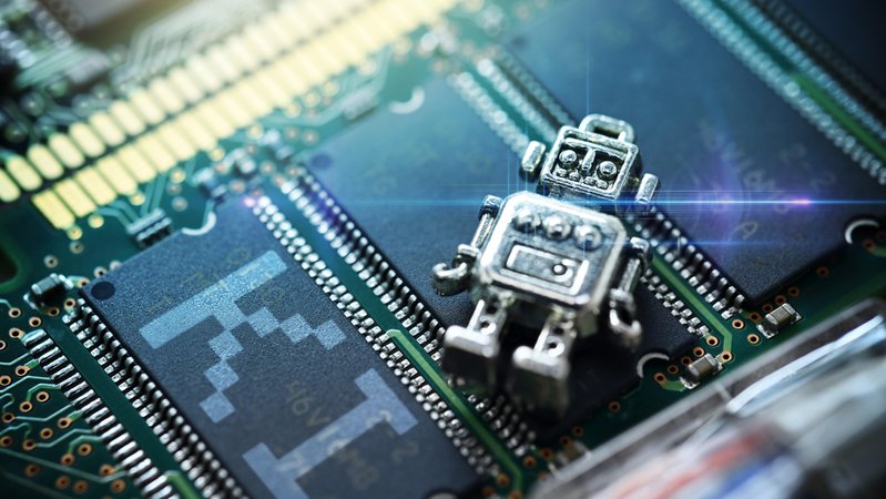 Miniatur-Roboter auf einer Computerplatine mit Schriftzug KI, Symbolfoto Künstliche Intelligenz 