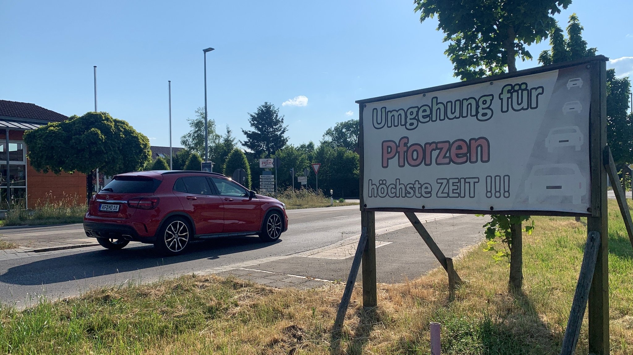 Pforzen: Auf einem Schild am Straßenrand steht: Umgehung für Pforzen - höchste Zeit 