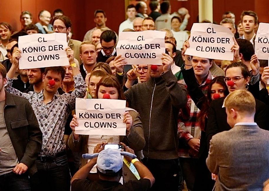 Während der Rede des FDP-Vorsitzenden Christian Lindner halten Protestierende Plakate mit der Aufschrift "CL König der Clowns" bei einer Wahlkampfveranstaltung im Kolpinghaus hoch. Die jungen Demonstranten tragen dabei zum Teil rote Clownsnasen.