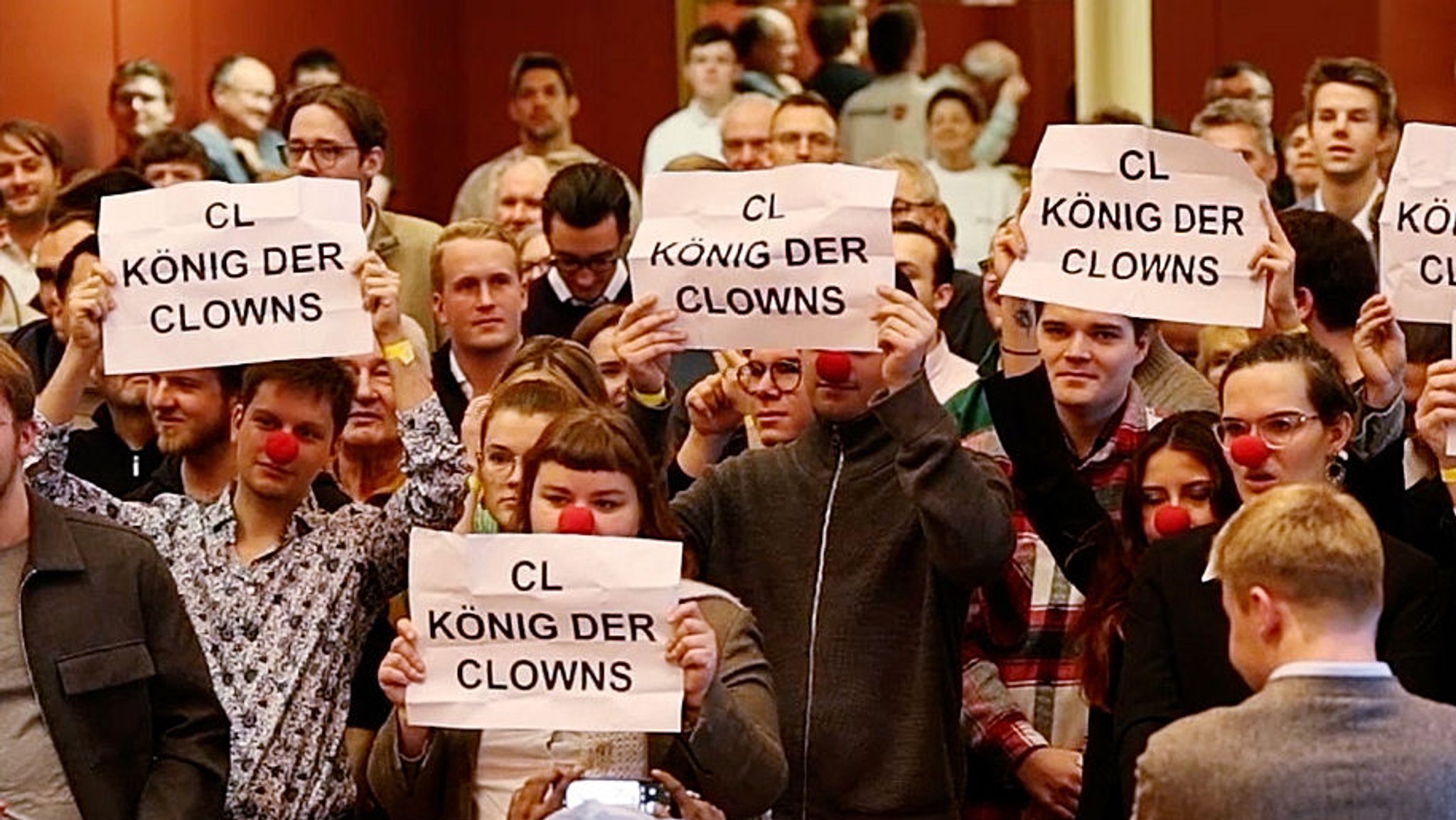 Während der Rede des FDP-Vorsitzenden Christian Lindner halten Protestierende Plakate mit der Aufschrift "CL König der Clowns" bei einer Wahlkampfveranstaltung im Kolpinghaus hoch. Die jungen Demonstranten tragen dabei zum Teil rote Clownsnasen.