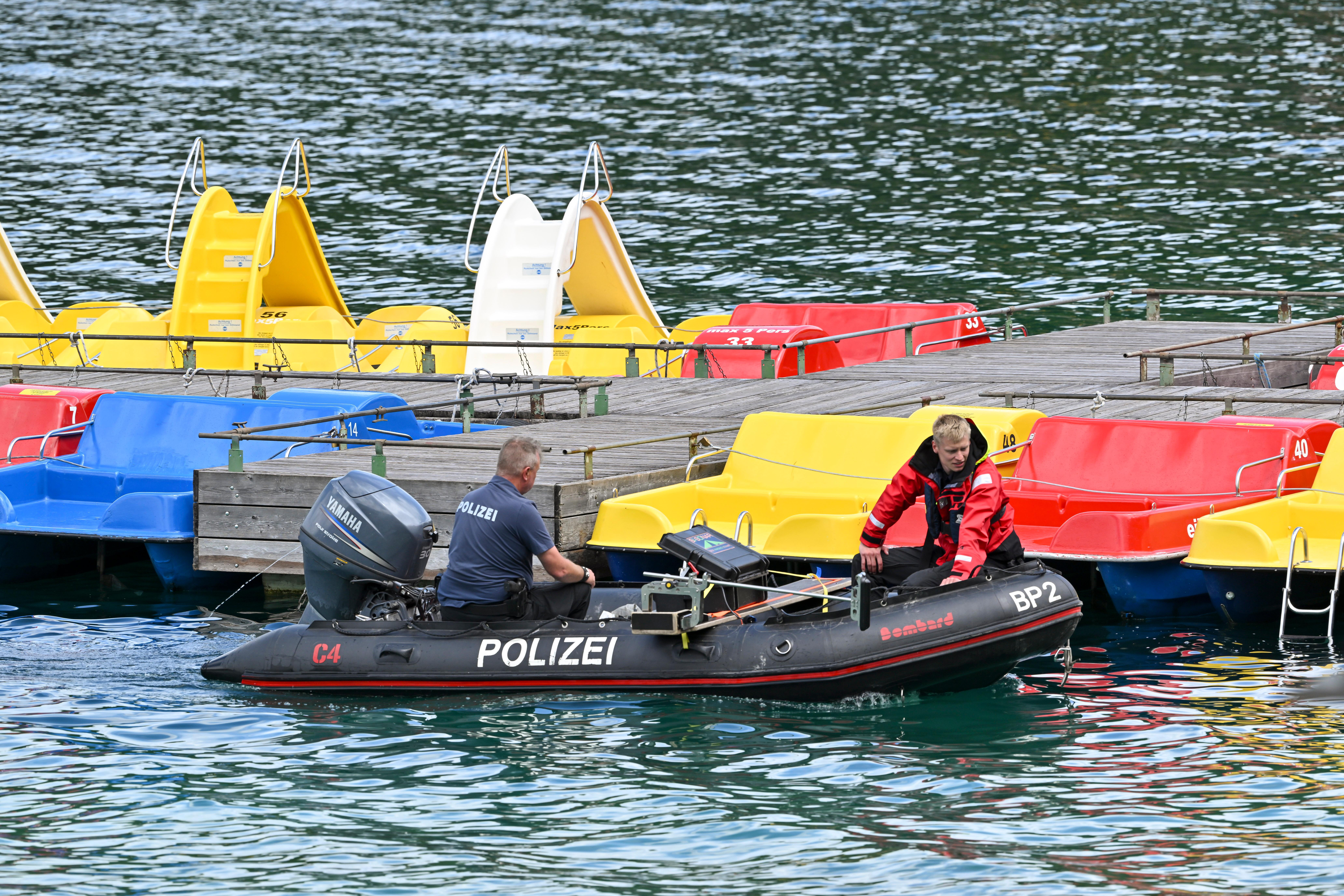 Polizeitaucher fahren in einem Schlauchboot vor den Tretbooten eines geschlossenen Bootsverleihs auf den Eibsee.