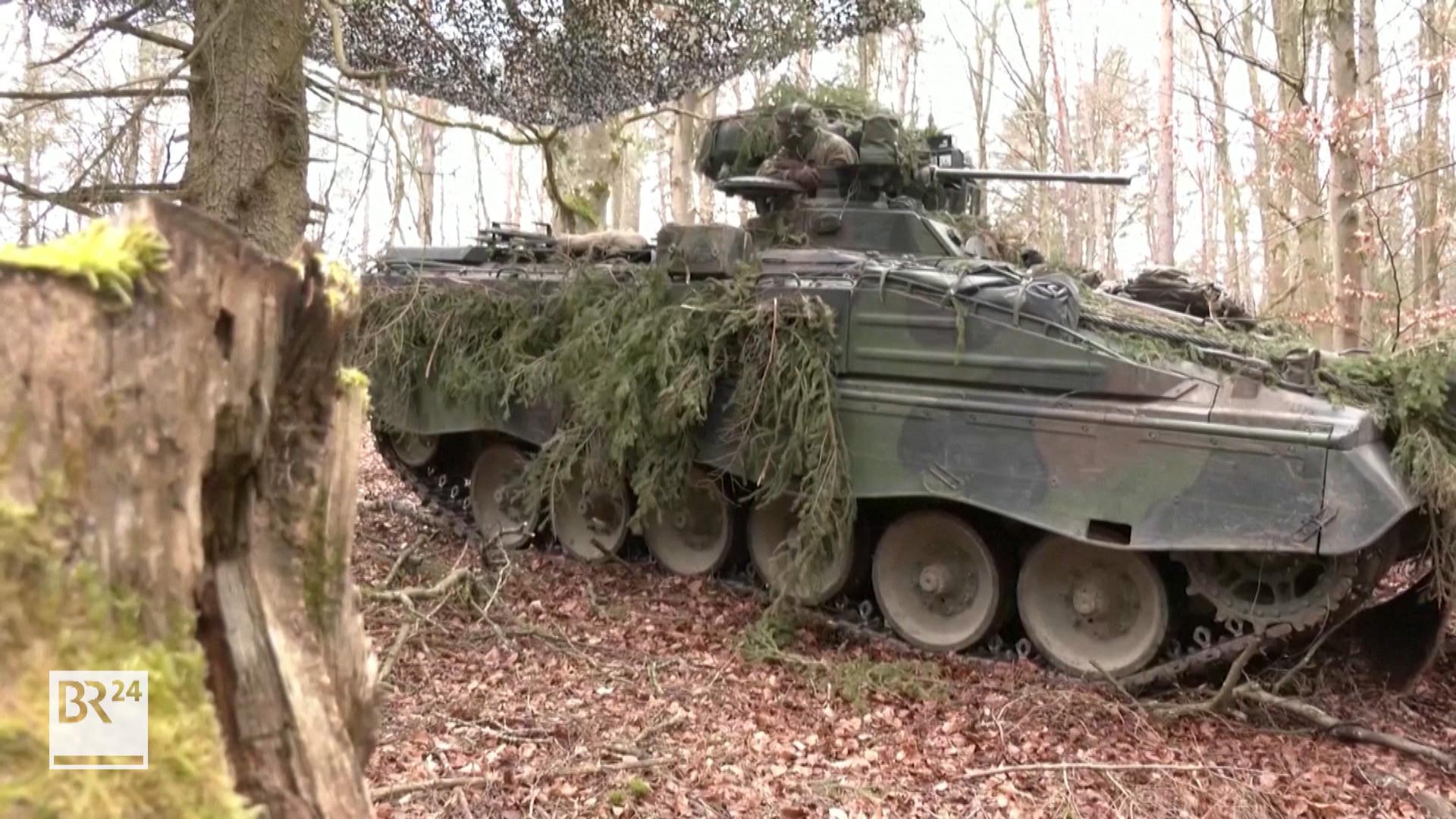 Ein Panzer der Bundeswehr fährt durch einen Wald.