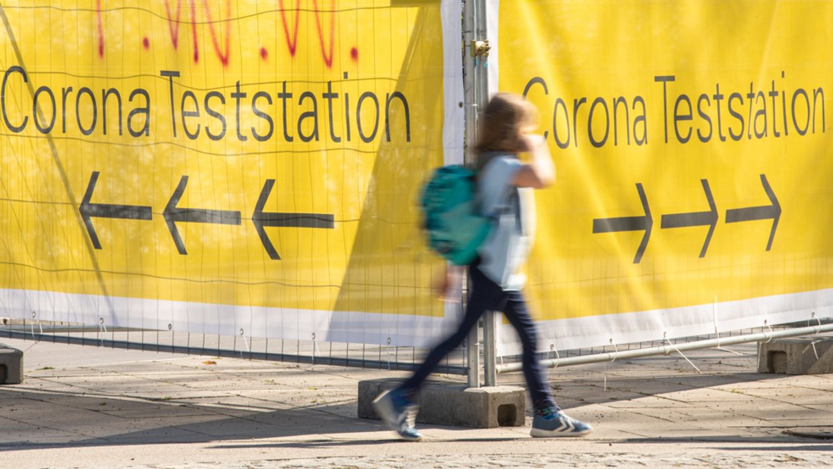 München: Große gelbe Banner mit der Aufschrift "Corona Teststation" hängen an Absperrgittern an der Theresienwiese in München.