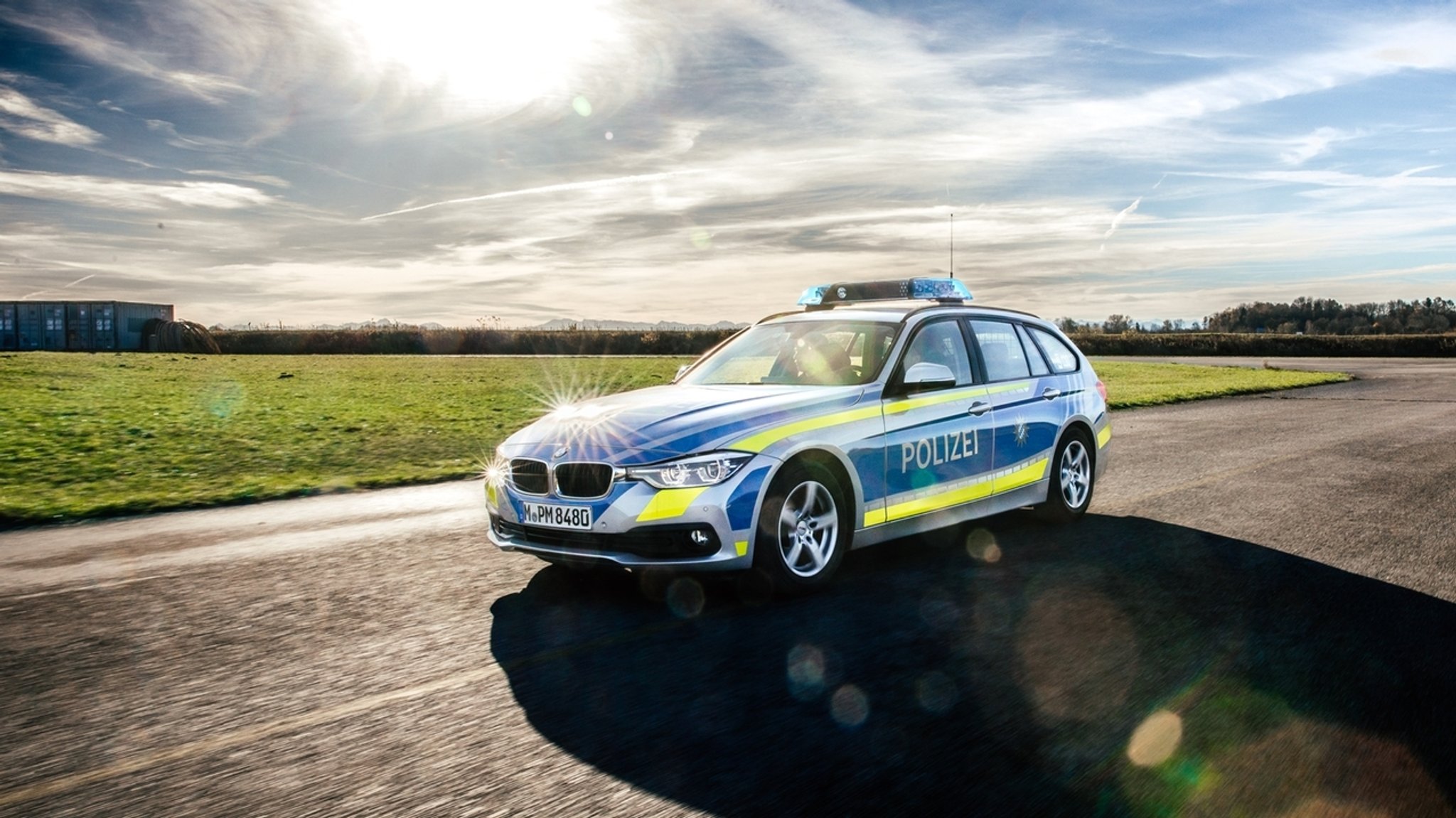 Polizeiauto mit Blaulicht auf einer Landstraße (Symbolbild).