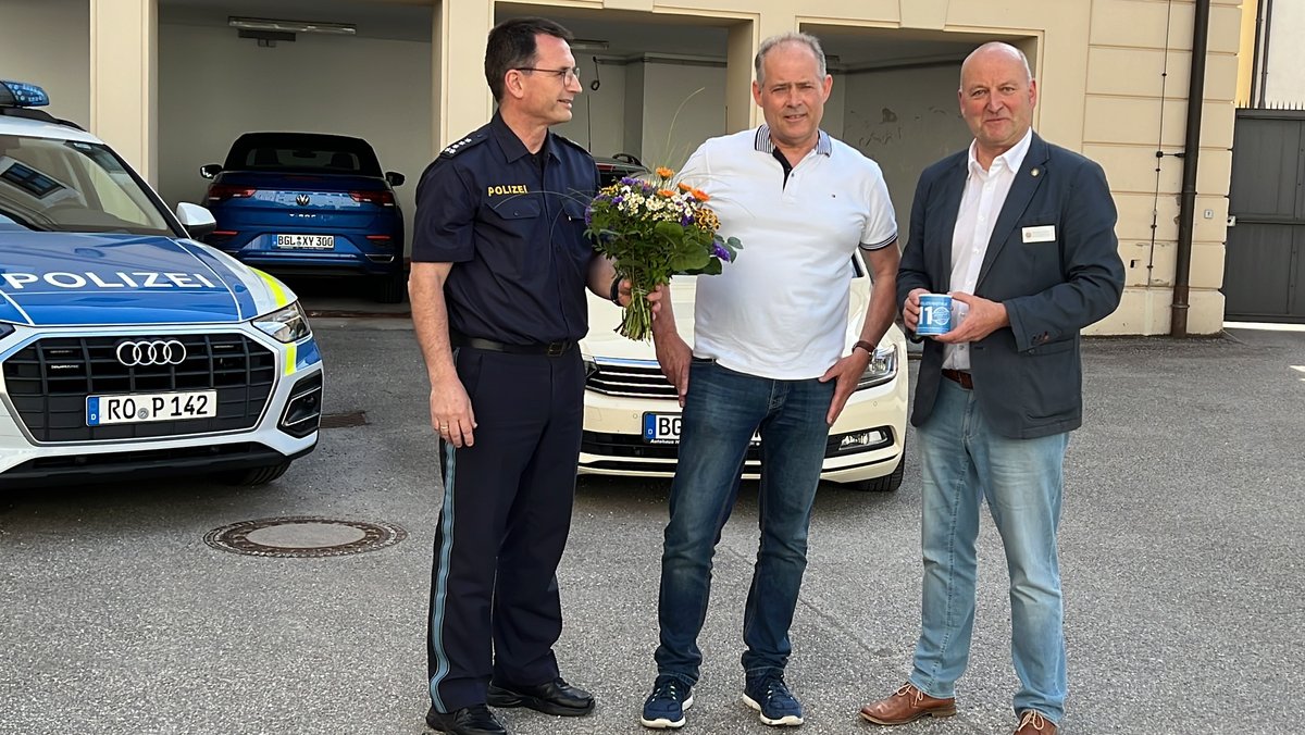 Leiter der Polizeiinspektion Bad Reichenhall übergibt Taxifahrer Blumenstrauß