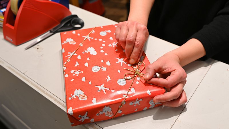 Weihnachtsgeschenk in rot-weißem Geschenkpapier. | Bild: picture alliance/dpa | Elisa Schu Weihnachtsgeschenk in rot-weißem Geschenkpapier.