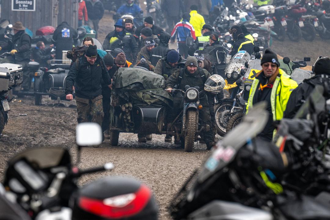 Personen mit Motorrädern, schlammiger Untergrund