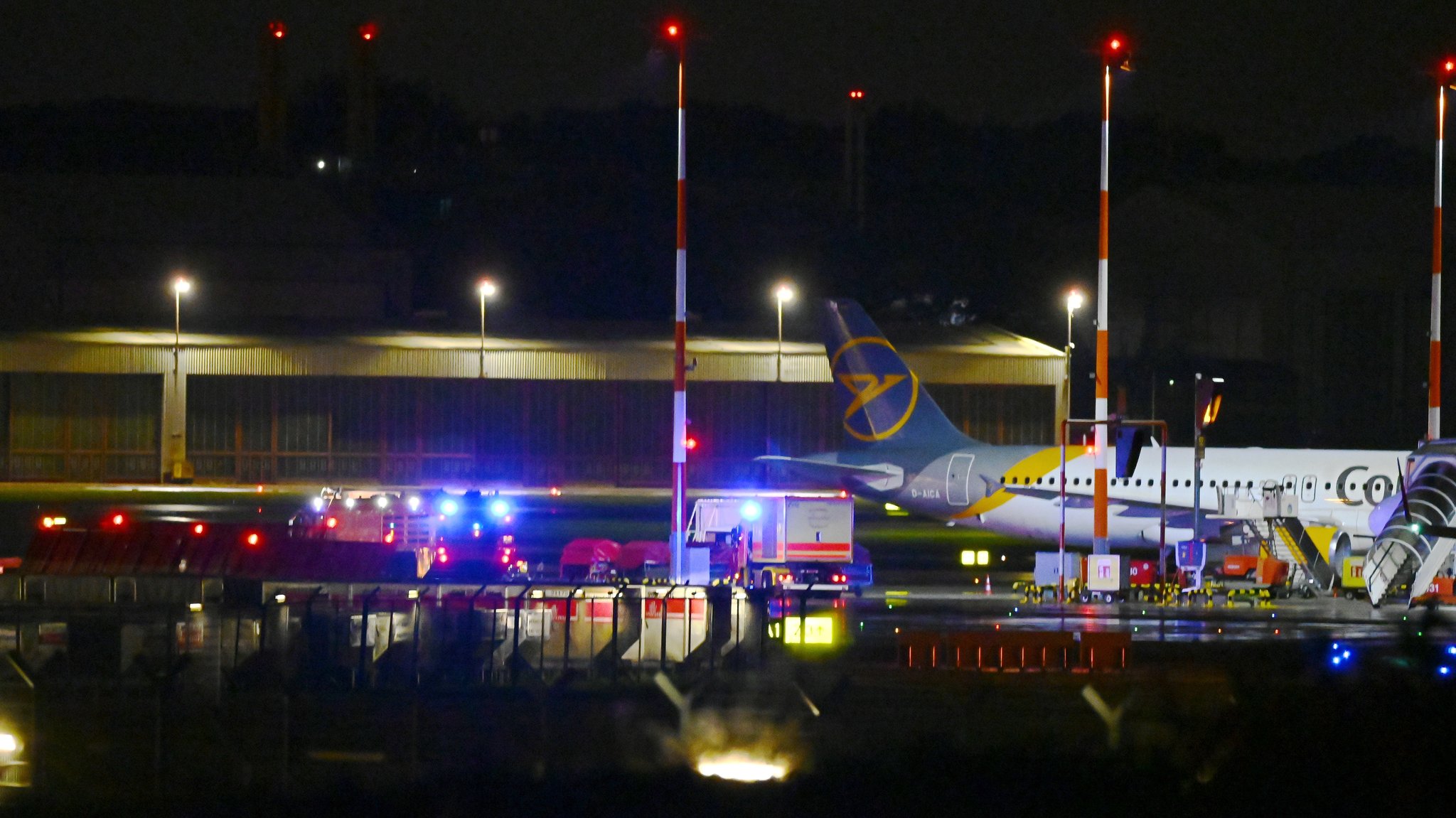 Einsatzkräfte stehen mit ihren Fahrzeugen am Hamburger Flughafen. 