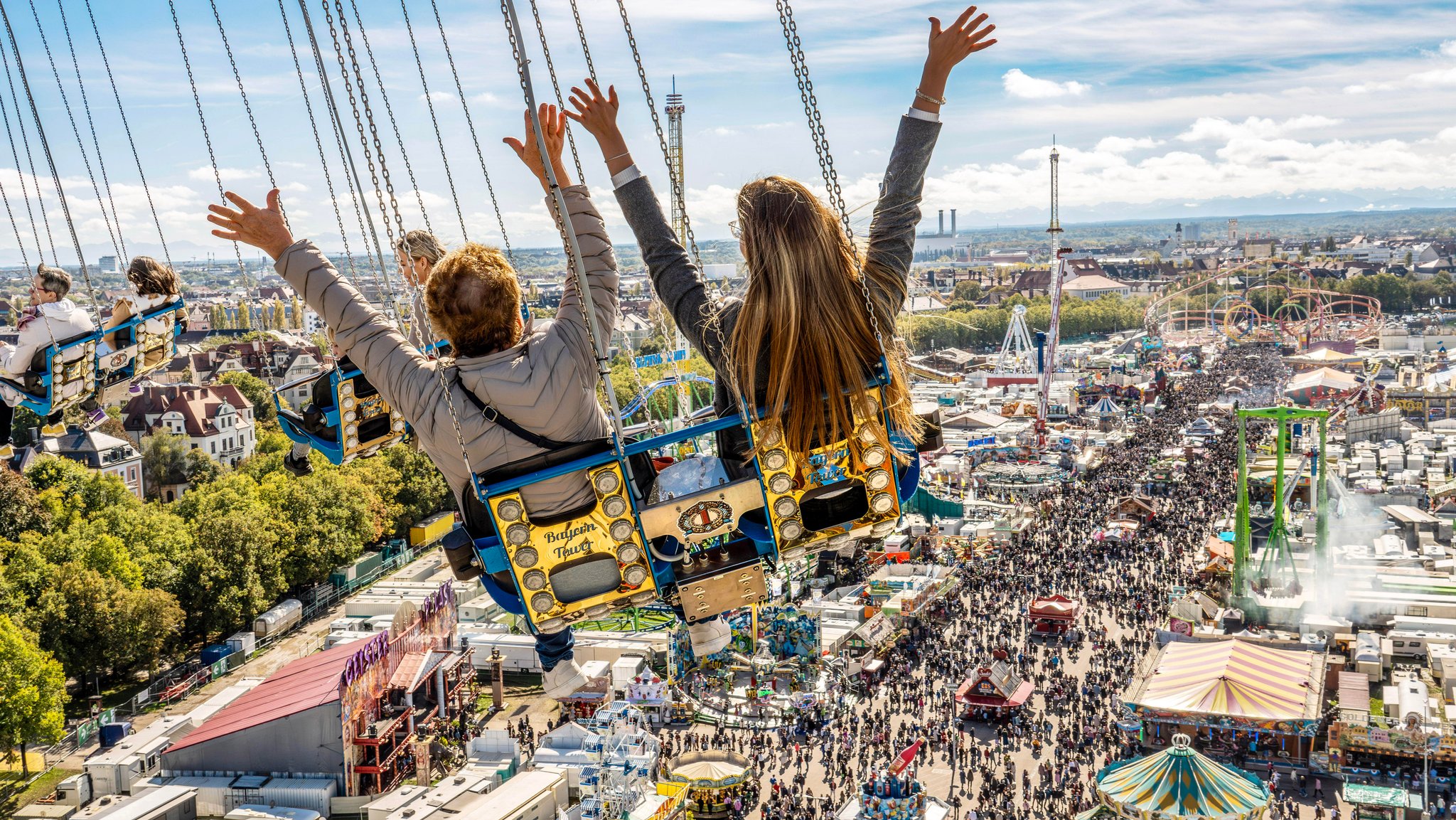 Bei Sonnenschein und strahlend blauem Himmel drehen Wiesnbesucher eine letzte Runde über der Festwiese