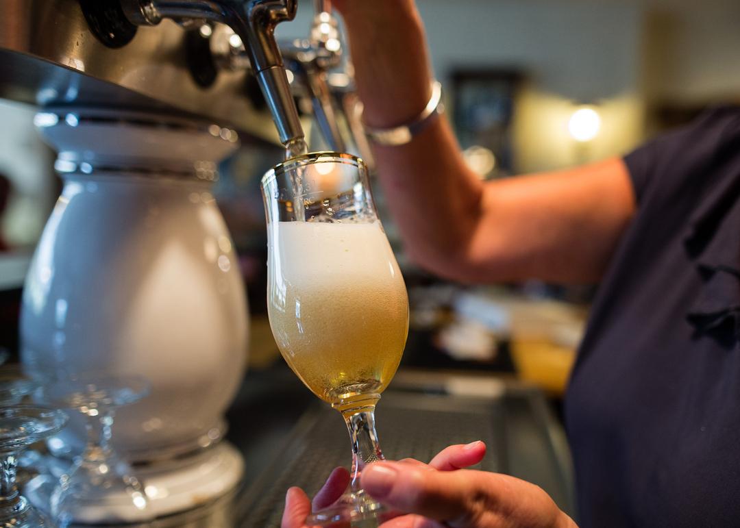 Eine Frau zapft in einer Gaststätte ein Pils.