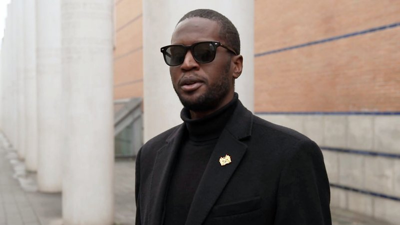 Malcolm Bidali steht vor den weißen Säulen in der Straße der Menschenrechte in Nürnberg | Bild: BR Malcolm Bidali steht vor den weißen Säulen in der Straße der Menschenrechte in Nürnberg