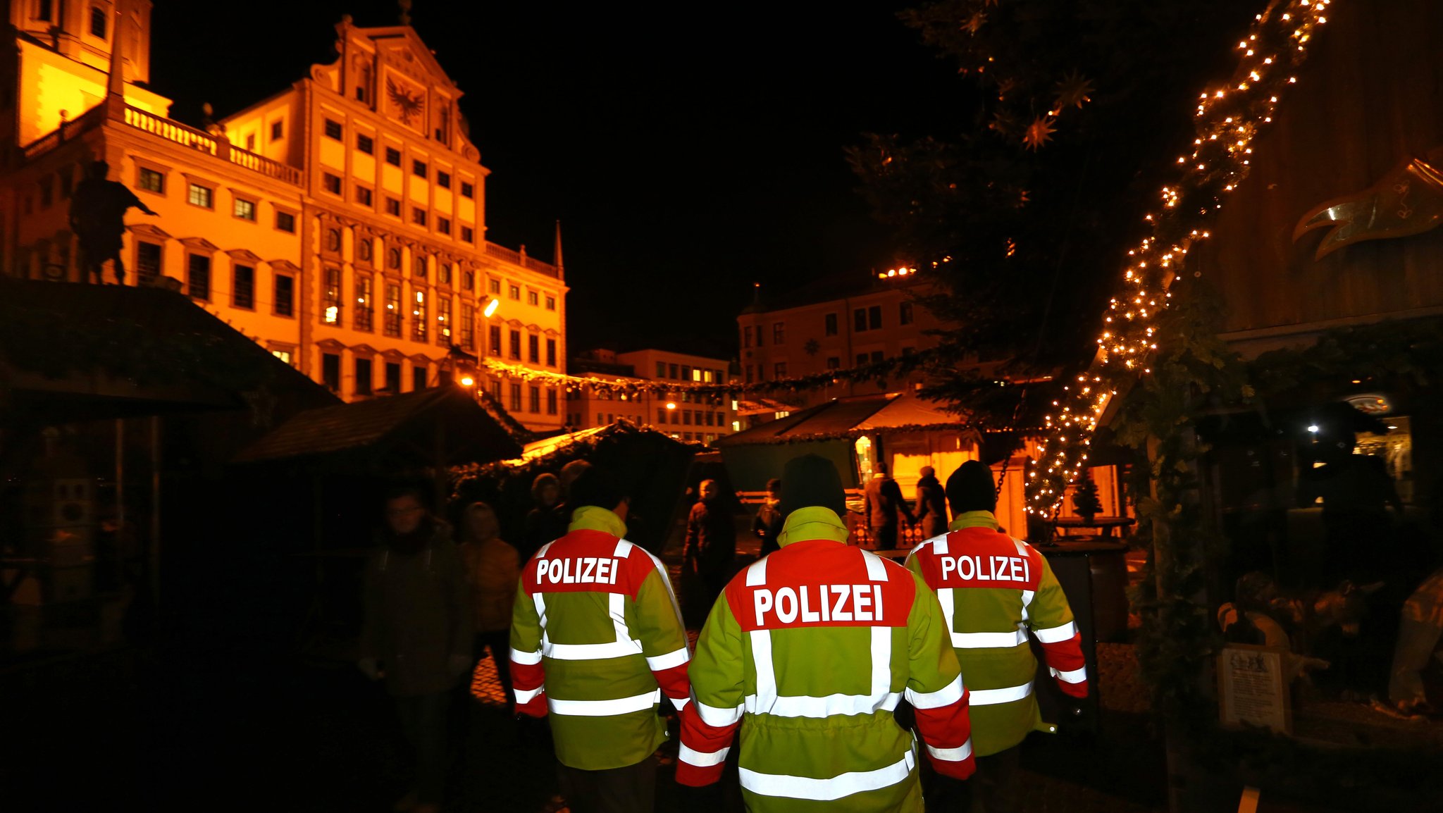 Polizeibeamte in gelben Sicherheits-Anoraks im Einsatz auf dem Christkindlesmarkt in Augsburg