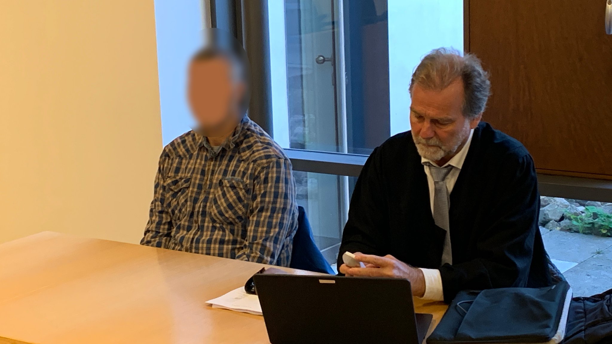 Ein Angeklagter sitzt in einem Gerichtssaal (links), neben ihm sitzt sein Anwalt. | Bild: BR/Norbert Steiche Ein Angeklagter sitzt in einem Gerichtssaal (links), neben ihm sitzt sein Anwalt.