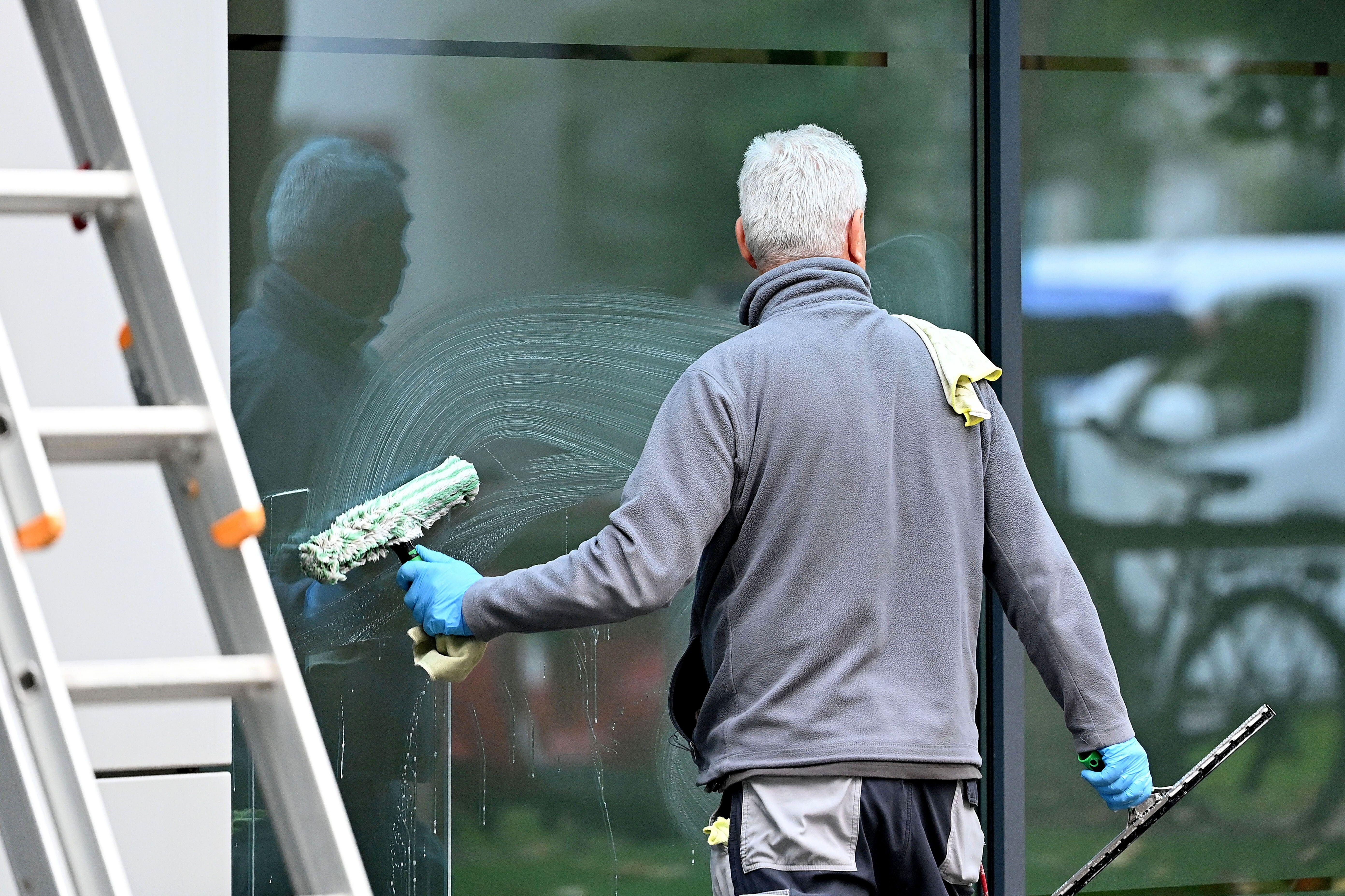 Ein Fensterputzer bei der Arbeit.  | Bild:picture alliance / SvenSimon | Frank Hoermann / SVEN SIMON