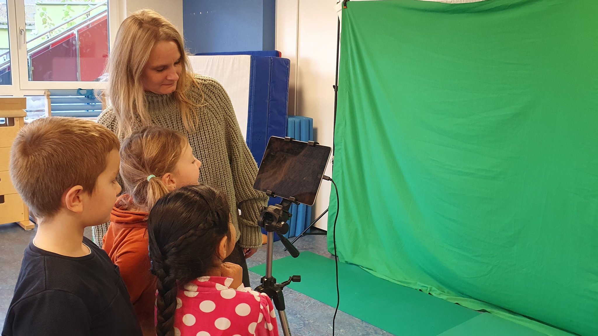 Kinder arbeiten mit dem Tablet für ein Filmprojekt.