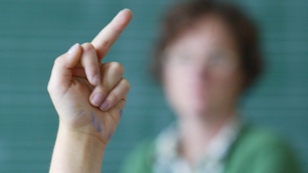 Symbolbild: Schülerin zeigt den Mittelfinger