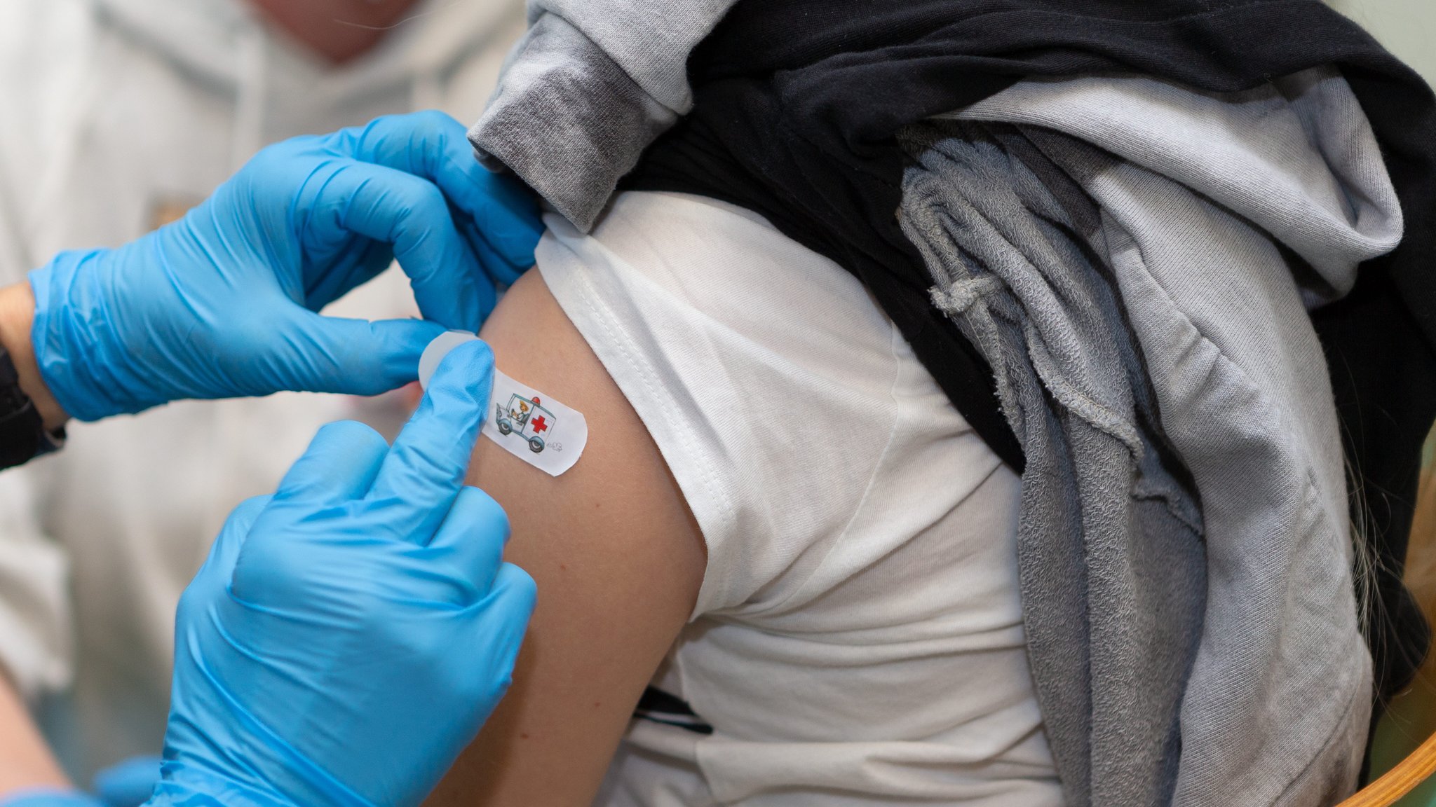 Bei einem Impftermin für Kinder zur Schutzimpfung gegen das Coronavirus, wird einem Kind nach der Impfung, ein Pflaster auf die Einstichstelle geklebt.