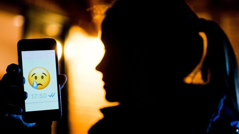 Ein junges Mädchen zeigt das Display eines Smartphones mit einem weinenden Emoji bem Messenger «WhatsApp» (gestellte Szene). | Bild: dpa-Bildfunk/Julian Stratenschulte Ein junges Mädchen zeigt das Display eines Smartphones mit einem weinenden Emoji bem Messenger «WhatsApp» (gestellte Szene).