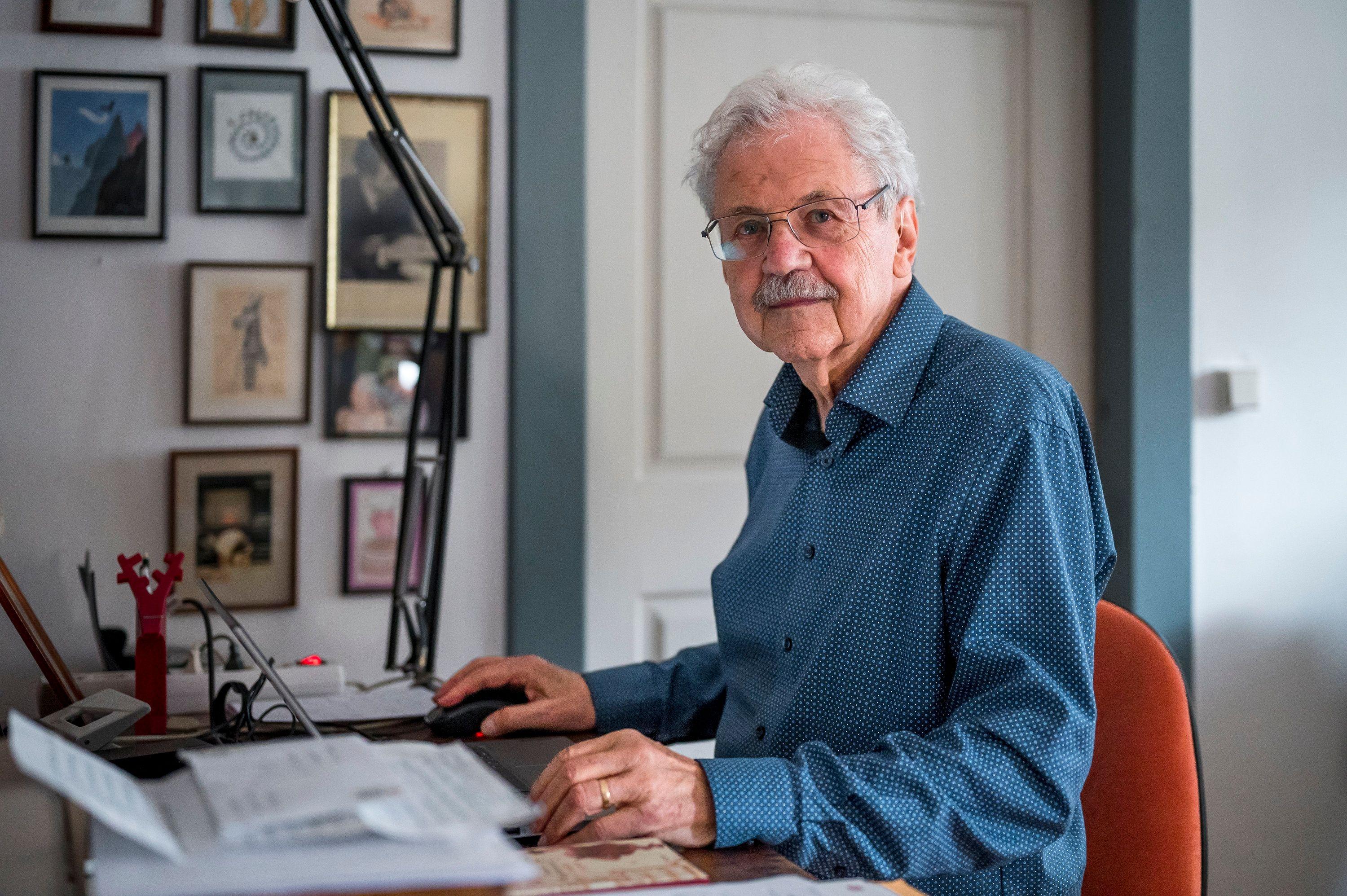 Paul Maar im blauen Hemd an seinem Schreibtisch 