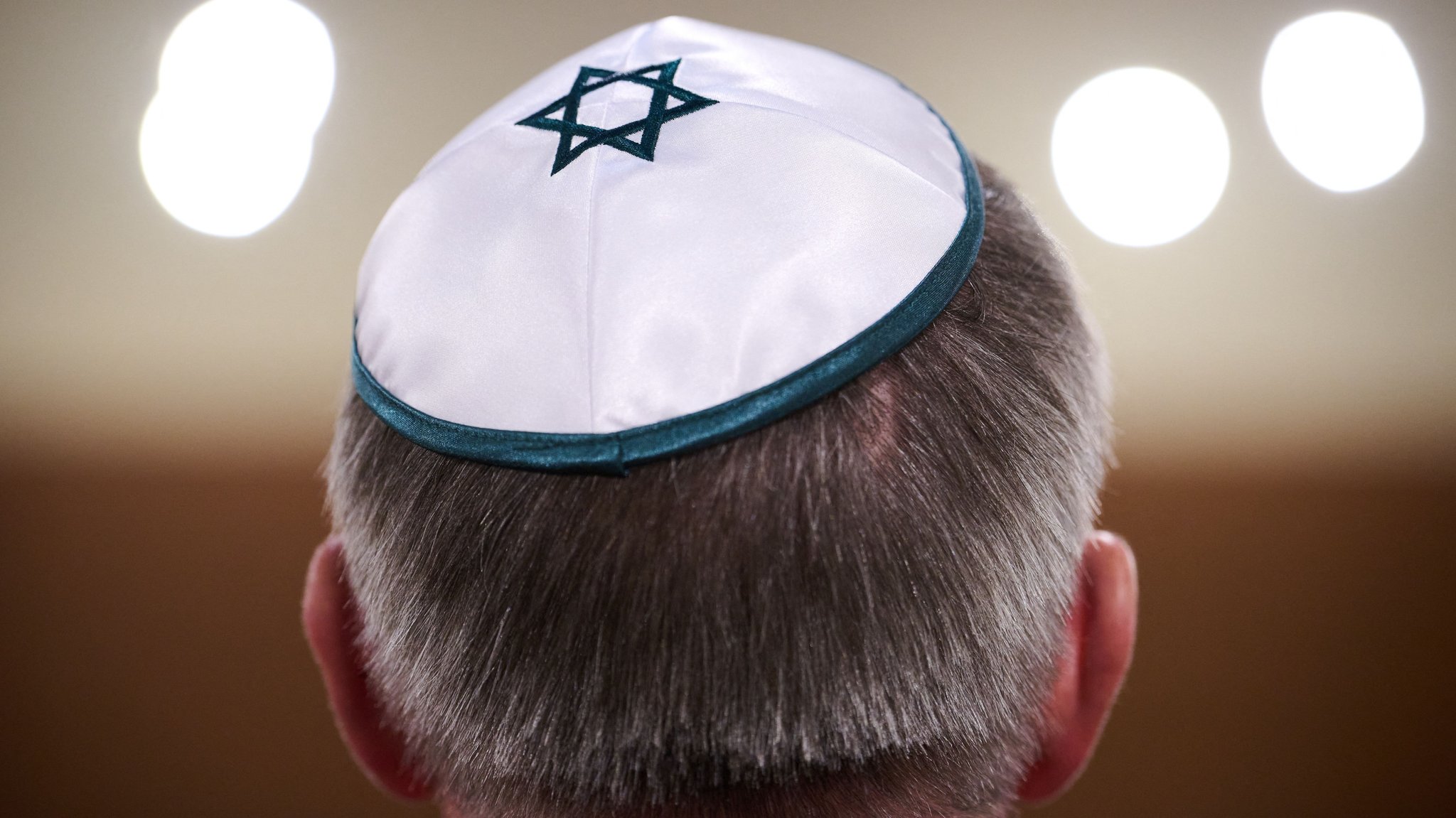 (Symbolbild): Der Kopf eines Mannes von Hinten. Er trägt eine Kippa mit eingesticktem blauen Davidstern. 