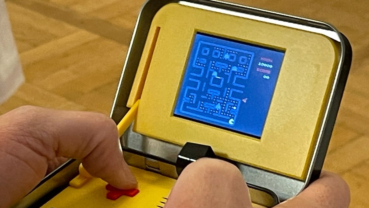 Eine Person spielt Pac-man auf einer Spielekonsole.