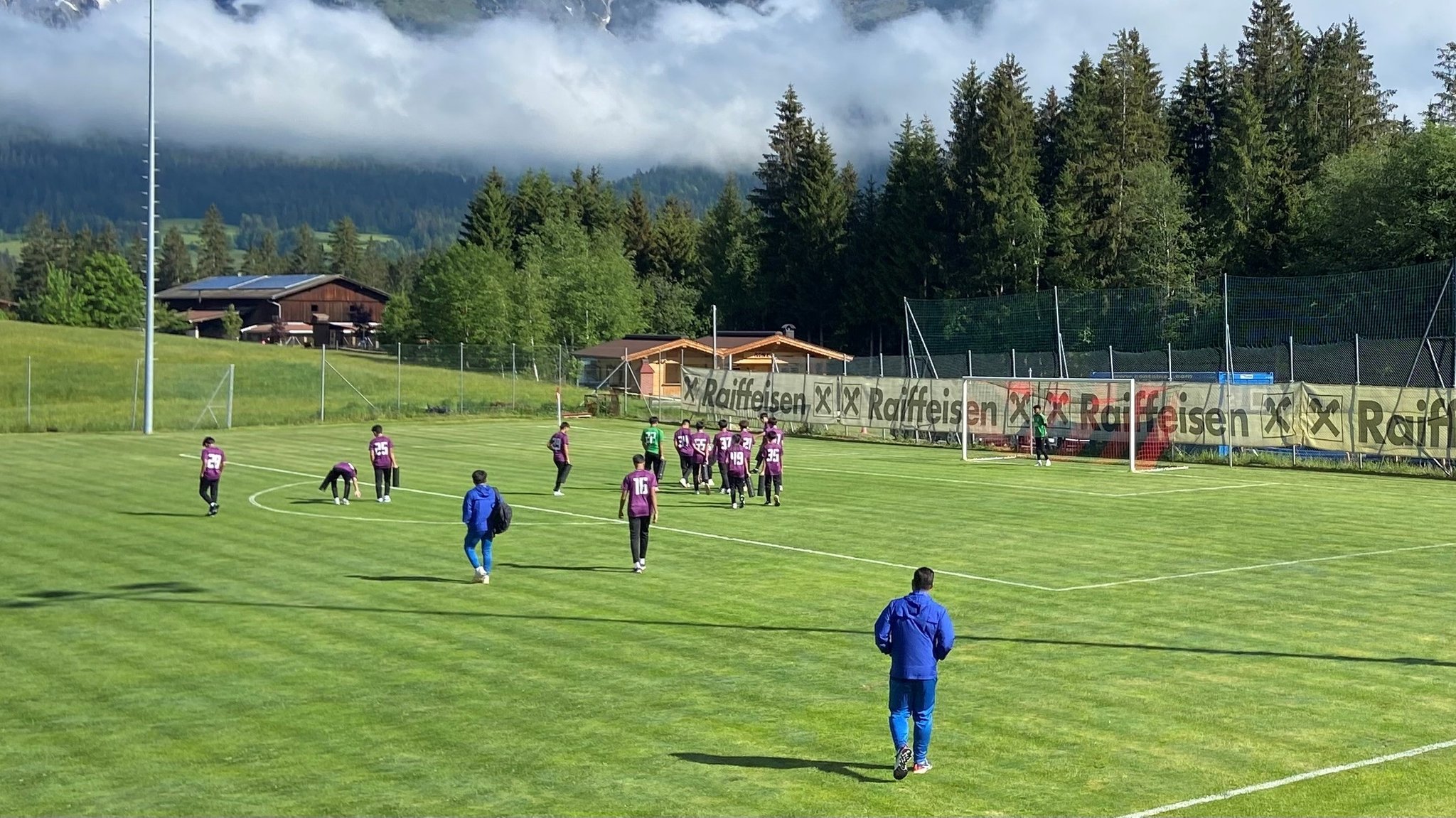 Spieler auf einem Fußballplatz vor einem Bergpanorama