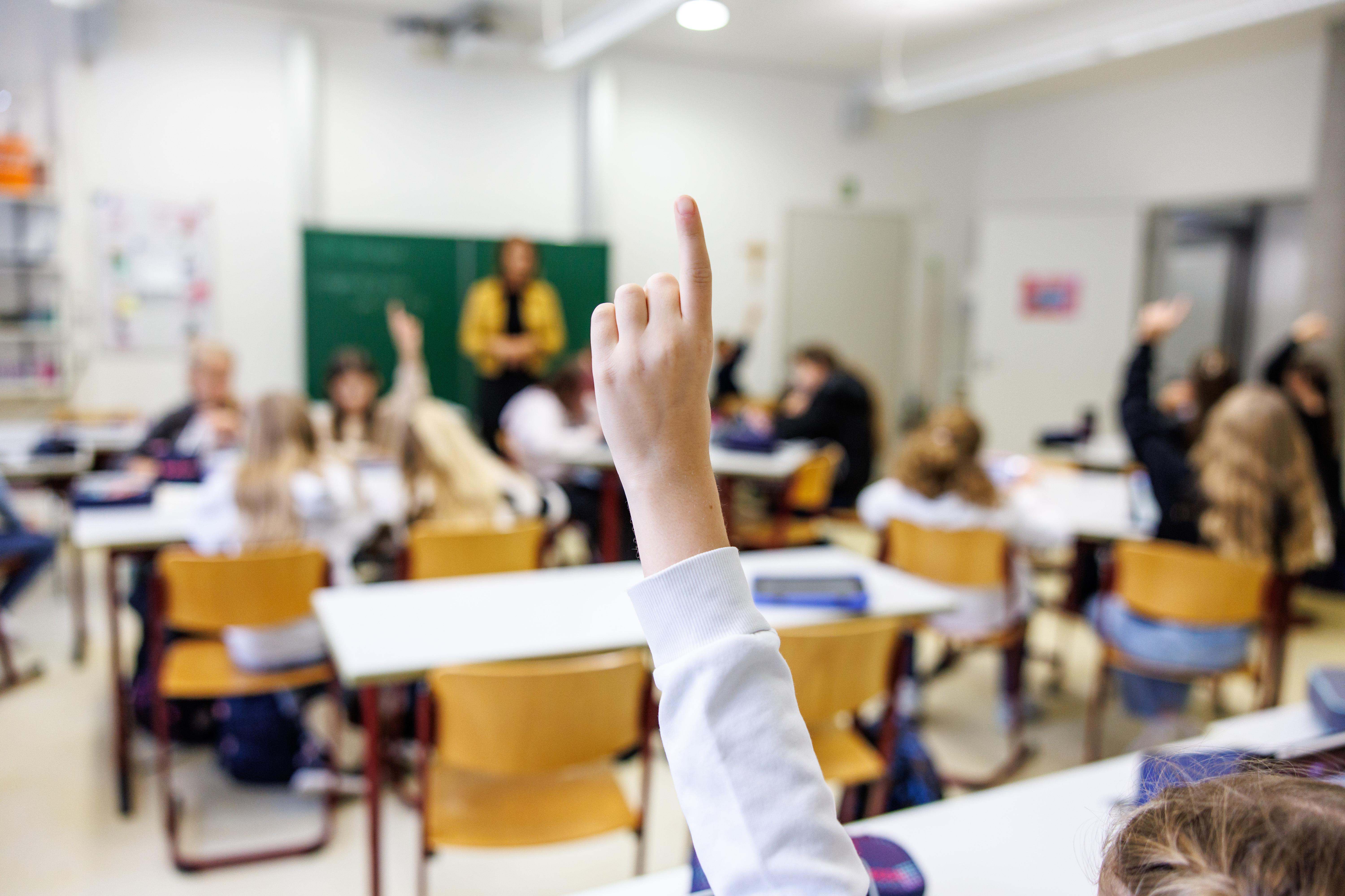 Symbolbild: Schülerinnen einer sechsten Klasse melden sich in einem Klassenraum.