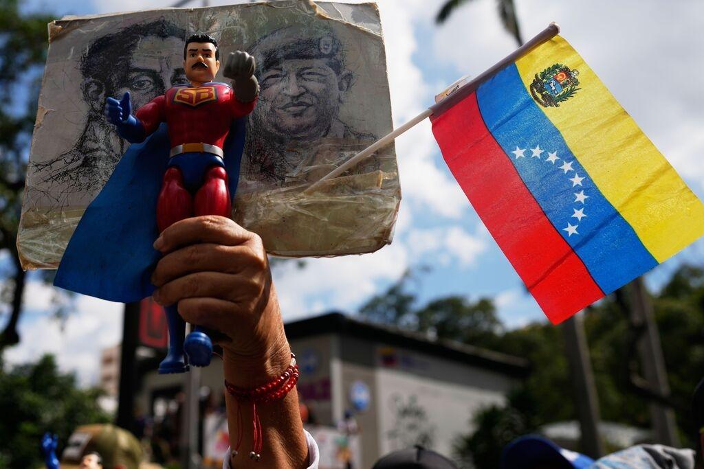 04.01.2026, Venezuela, Caracas: Ein Anhänger der Regierung hält eine Action-Figur von Super Bigote während einer Demonstration, bei der die Freilassung von Präsident Nicolas Maduro gefordert wird, nachdem die US-Streitkräfte ihn gefangen genommen und in die Vereinigten Staaten geflogen haben. Foto: Ariana Cubillos/AP/dpa +++ dpa-Bildfunk +++