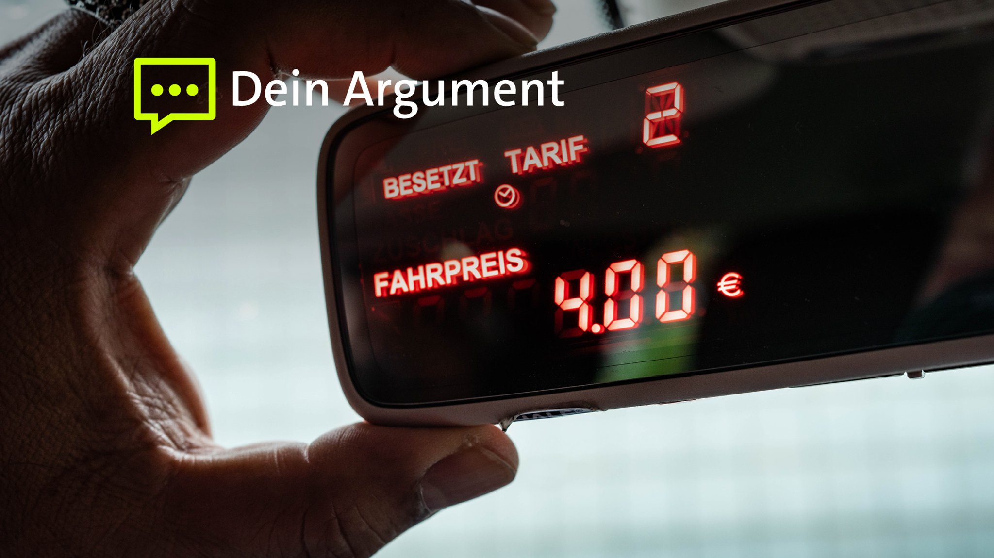 Ein Taxameter zeigt am Spiegel eines Autos einen Fahrpreis von 4 Euro an. Eine Hand hält den Spiegel. 