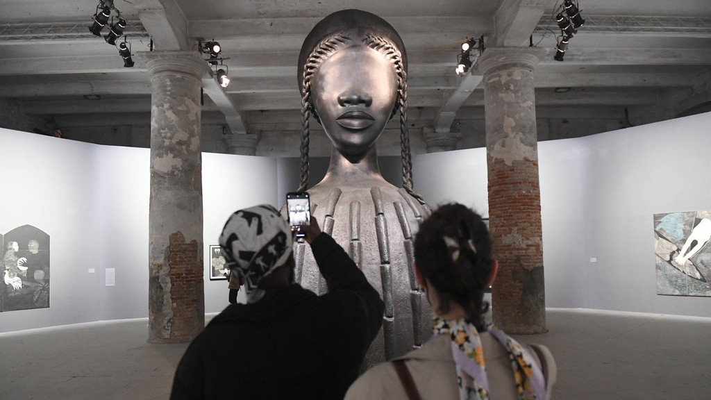  Besucher fotografieren bei der 59. Kunstbiennale die Installation «Brick House» der Künstlerin Simone Leigh. 