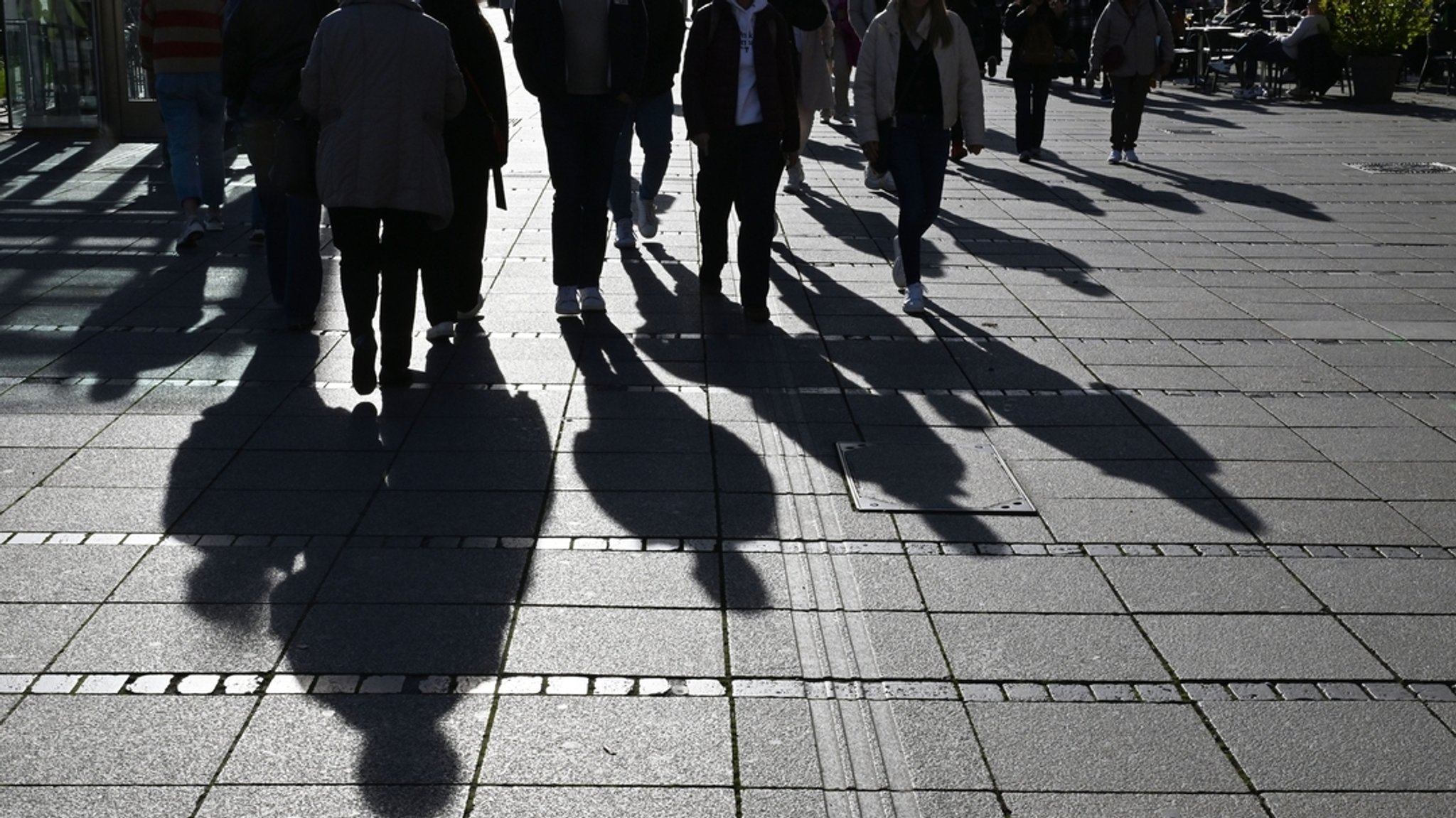 Schatten von Passanten erscheinen bei strahlendem Sonnenschein auf einem Gehweg. | Bild: dpa-Bildfunk/Bernd Weißbrod Schatten von Passanten erscheinen bei strahlendem Sonnenschein auf einem Gehweg.