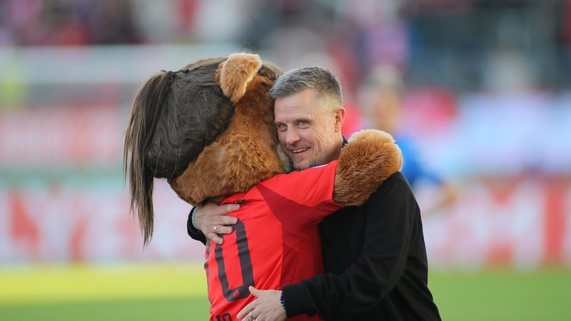 Campus Maskottchen Mia (li.) umarmt Alexander Straus , Trainer FC-Bayern-Frauen | Bild: picture-alliance/dpa Campus Maskottchen Mia (li.) umarmt Alexander Straus , Trainer FC-Bayern-Frauen