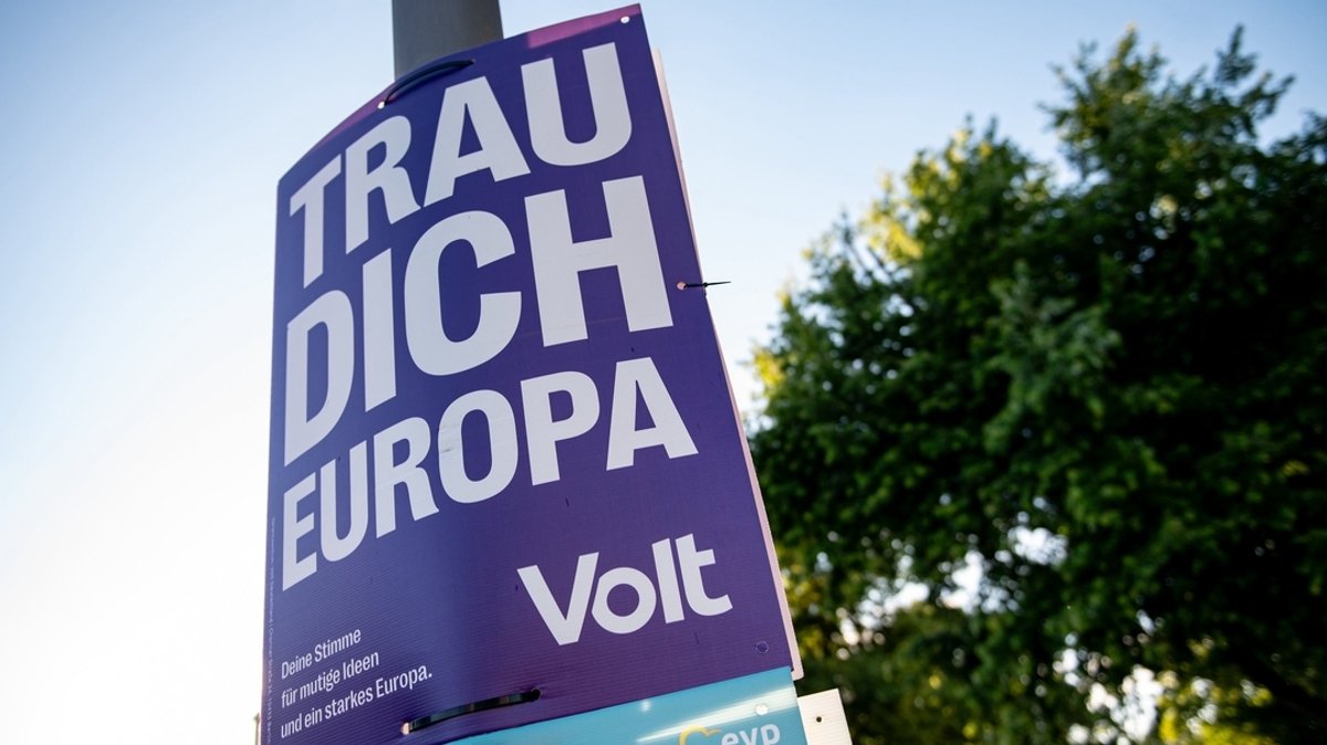 Ein Wahlplakat der Partei "Volt" hängt an einer Straßenlaterne.