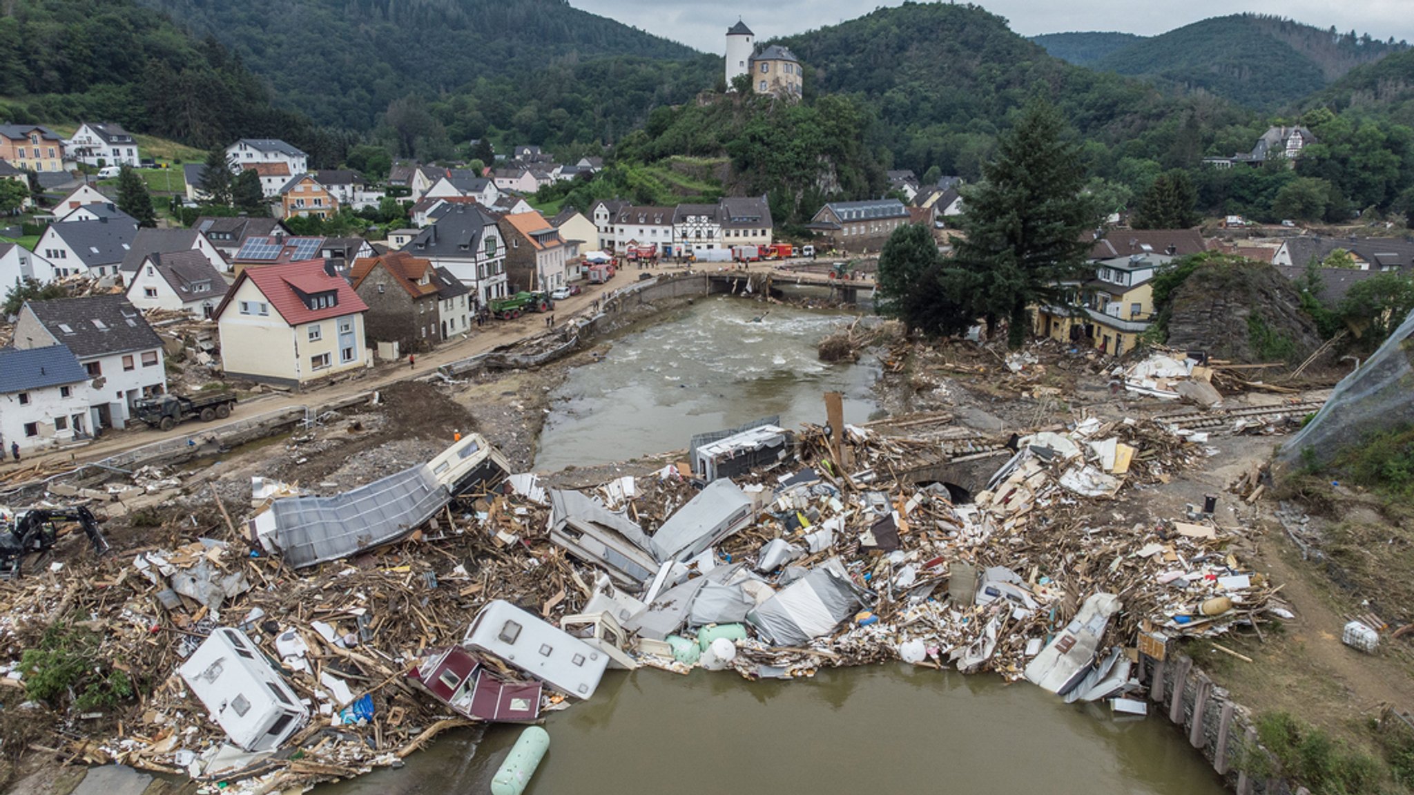 ARCHIV - 19.07.2021: Nach der Flut türmen sich Wohnwagen, Gastanks, Bäume und Schrott an einer Brücke über der Ahr in Altenahr meterhoch.