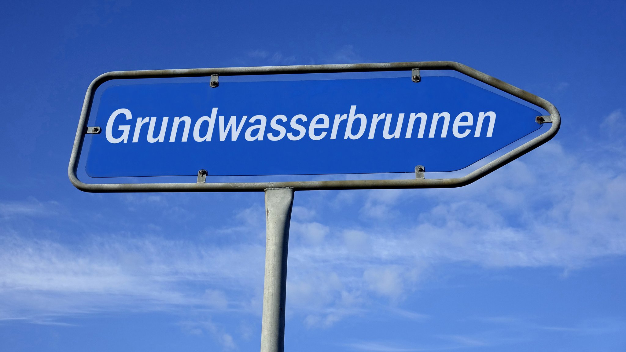 Auf einem Wegweiser befindet sich der Schriftzug Grundwasserbrunnen 