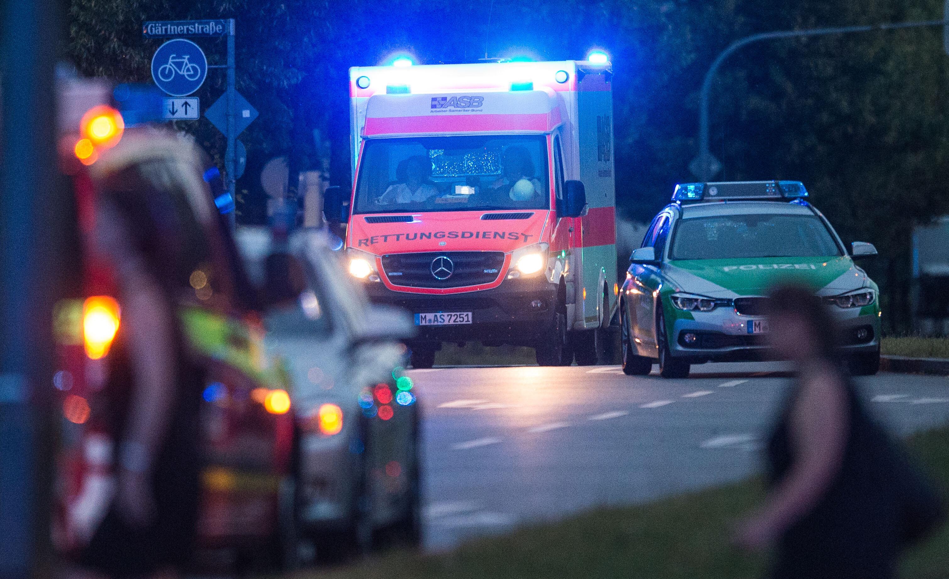 Ein Krankenwagen mit Blaulicht neben einem Polizeiwagen. 