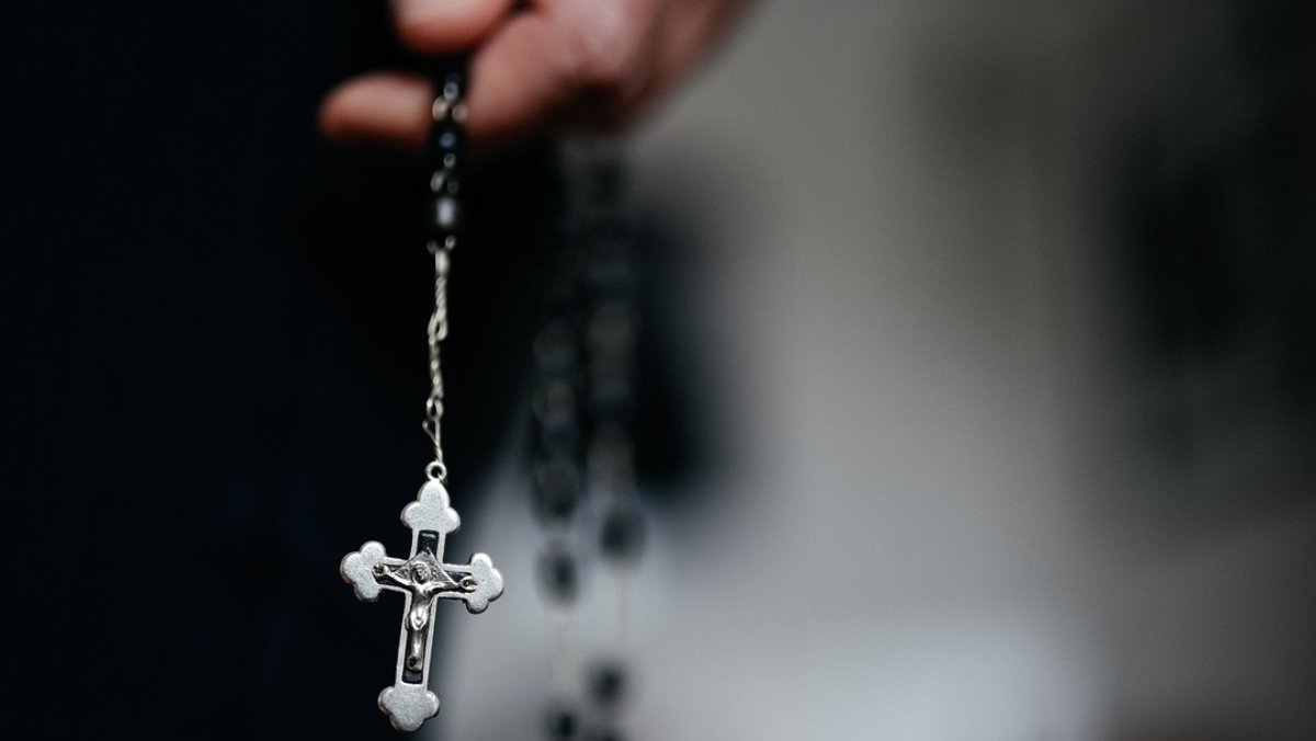 Symbolbild: Priester hält Rosenkranz in der Hand
