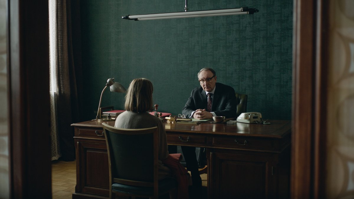 Karla (Elise Krieps) und Richter Lamy (Rainer Bock) sitzen sich in Lamys Büro gegenüber in "Karla" (Filmszene).