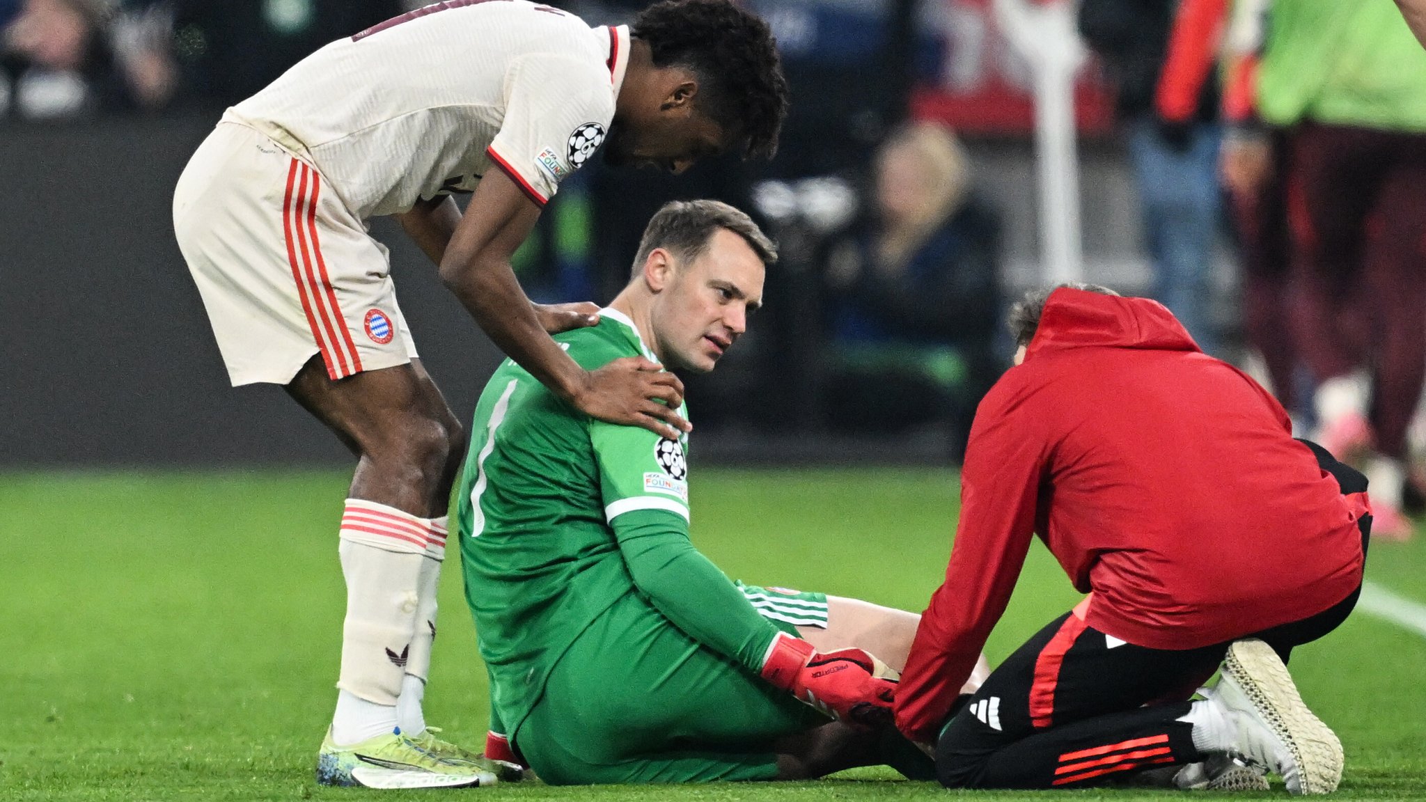 Manuel Neuer, Torhüter des FC Bayern, wird auf dem Spielfeld behandelt