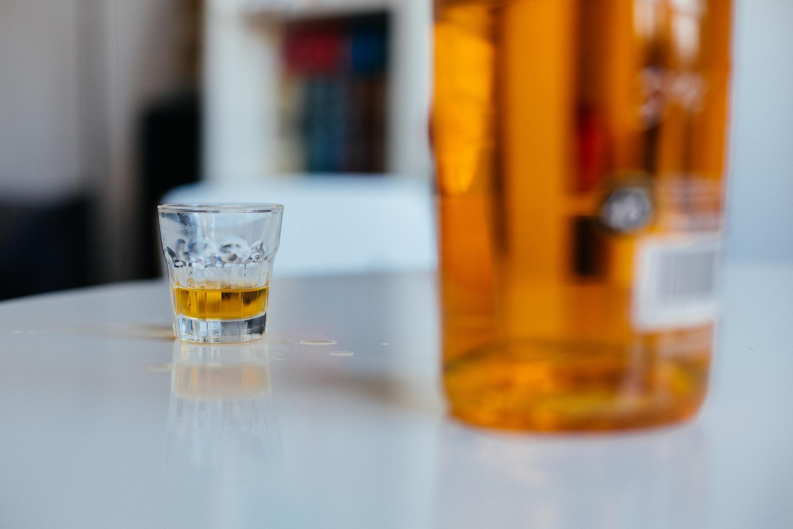 Symbolbild: Eine Flasche Schnaps und ein Glas stehen auf einem Tisch