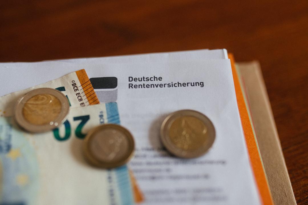 Ein Brief der Deutschen Rentenversicherung in einem Ordner mit Geld.