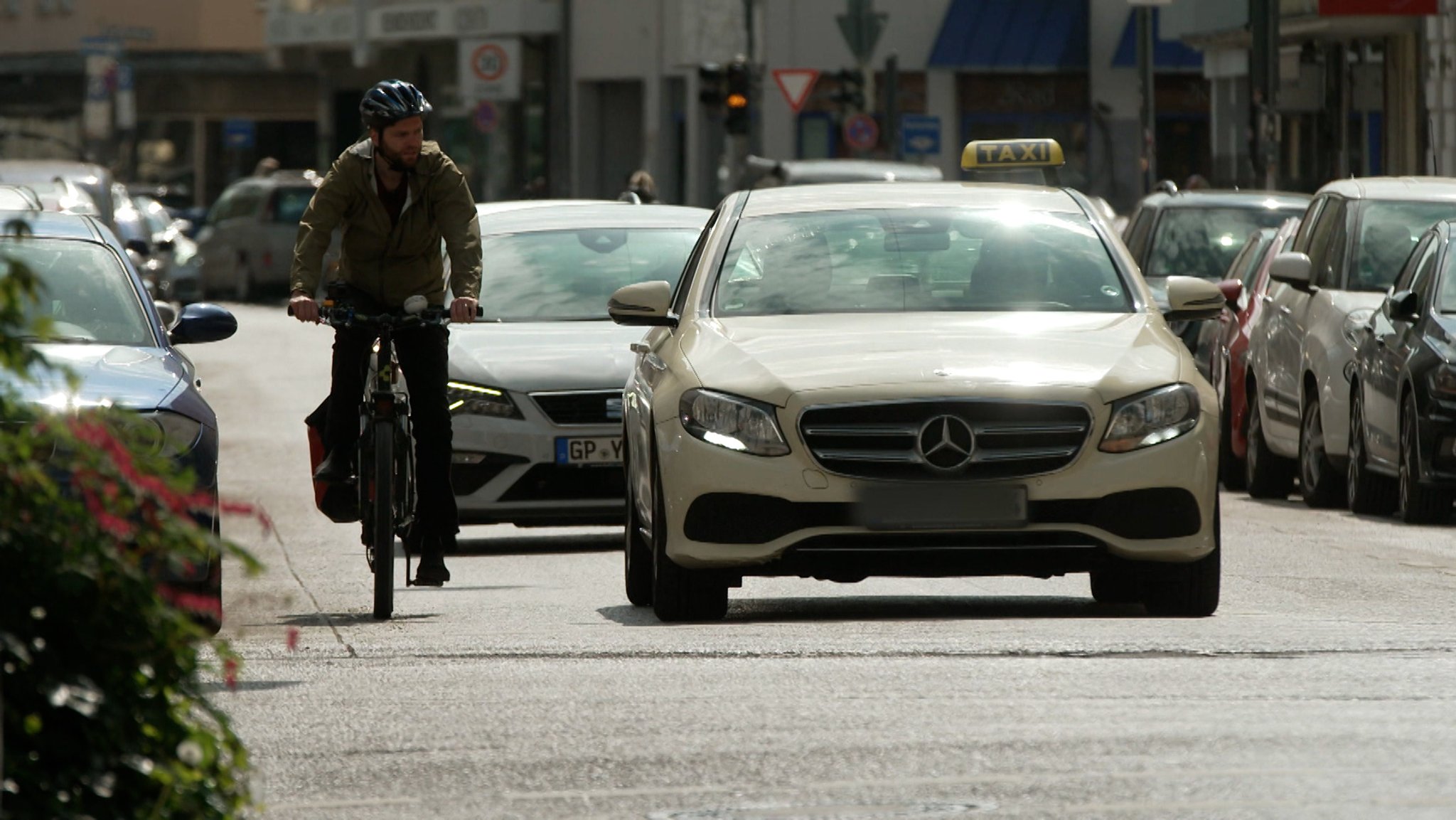 Radfahrer neben Autos