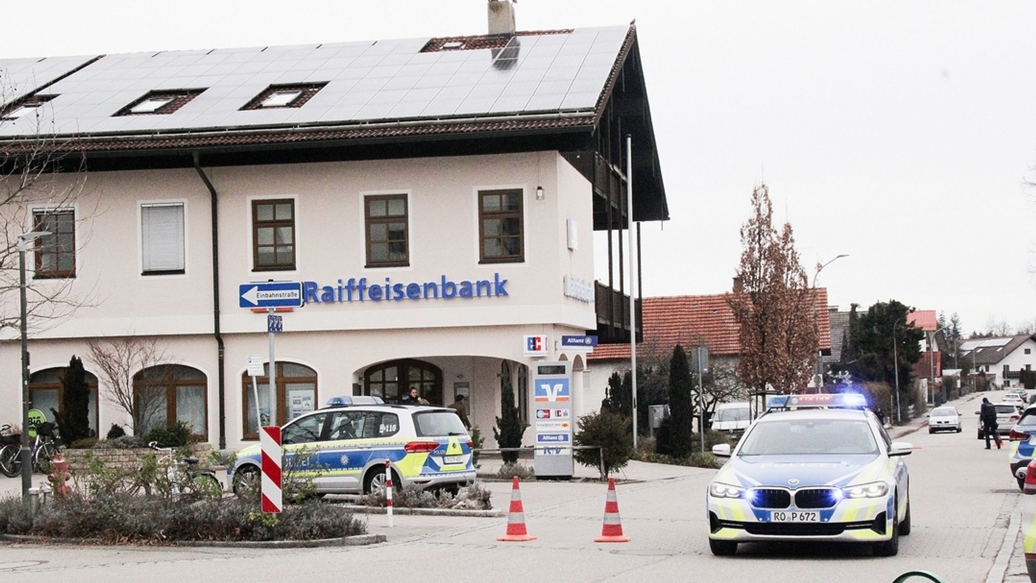 Einsatzkräfte der Polizei stehen nach einem Überfall auf einen Geldtransporter in der Nähe einer Bank.