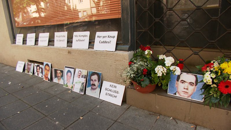 Blumen und Fotos der Opfer des NSU vor einem Ladengeschäft