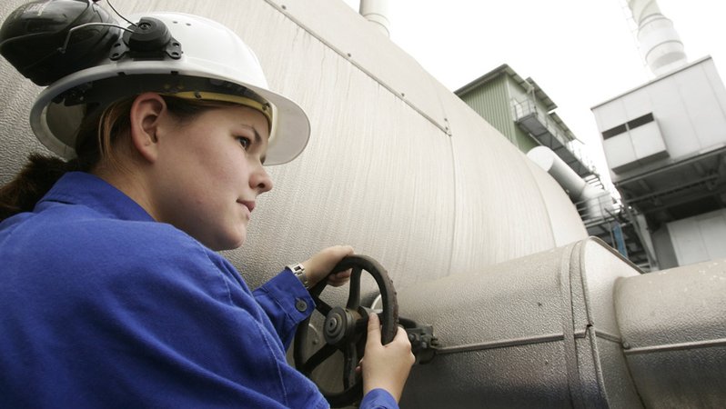 Junge Frau dreht in einem chemischen Unternehmen am Entgaser einer Wasserstoffanlage (Symbolbild).