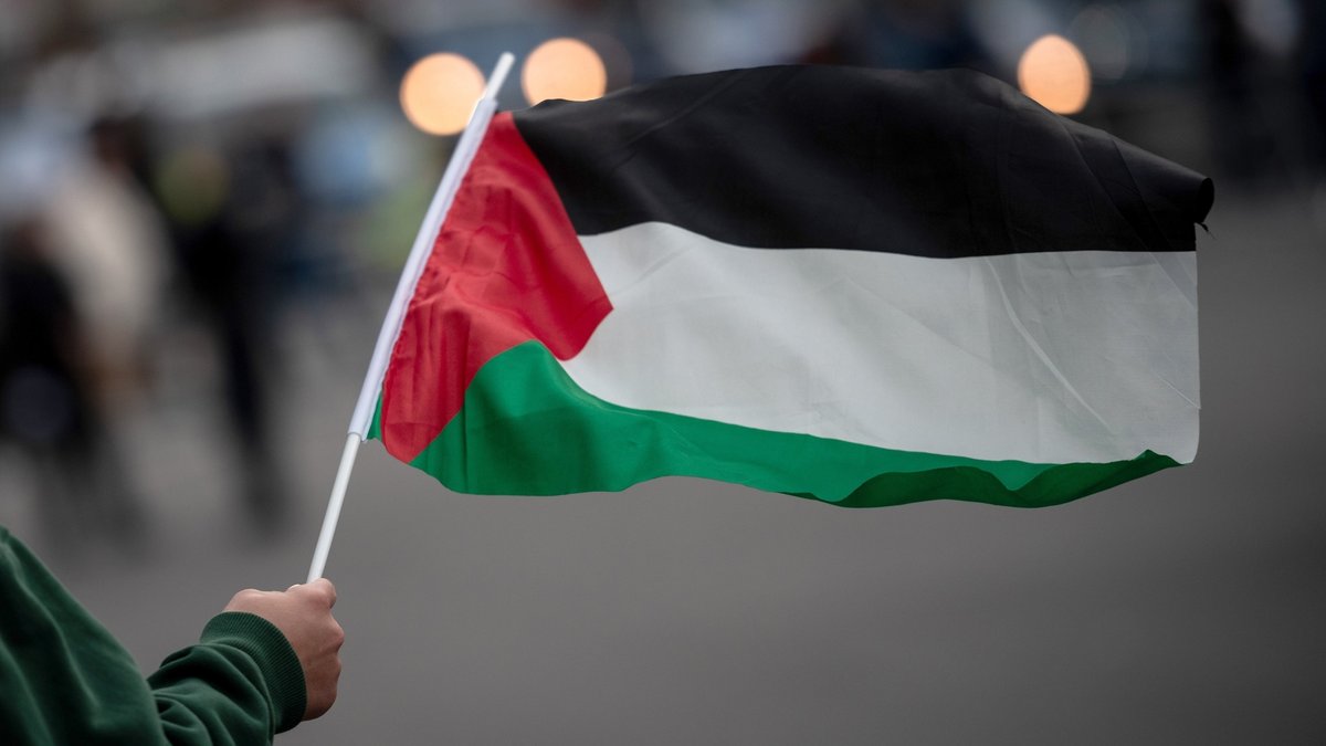 Eine Teilnehmerin einer pro-palästinensischen Demonstration hält eine palästinensische Fahne in der Hand. (Symbolbild)