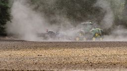 Ein Landwirt fährt mit einem Traktor und einer Egge über den trocken Ackerboden. | Bild:dpa-Bildfunk/Patrick Pleul