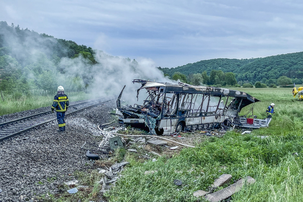Blaustein: Die Feuerwehr löscht einen Brand in einem Bus, der in der Nähe von Ulm mit einem Zug kollidierte.